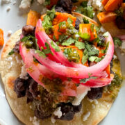 black bean tostadas with sweet potato, pickled onions, feta and cilantro lime sauce