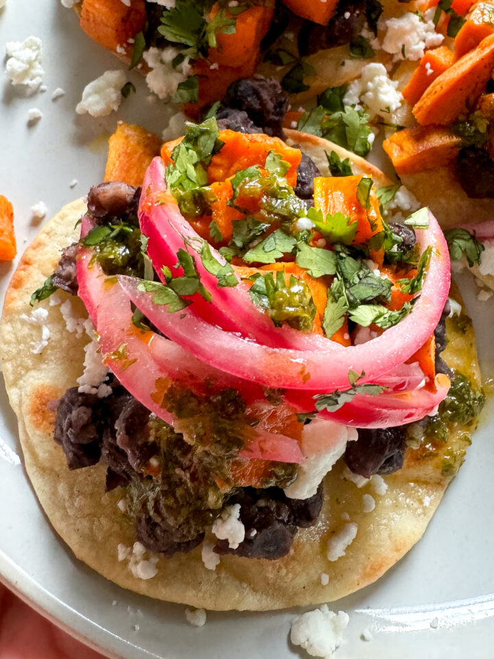 black bean tostadas with sweet potato, feta, pickled onions and cilantro lime sauce