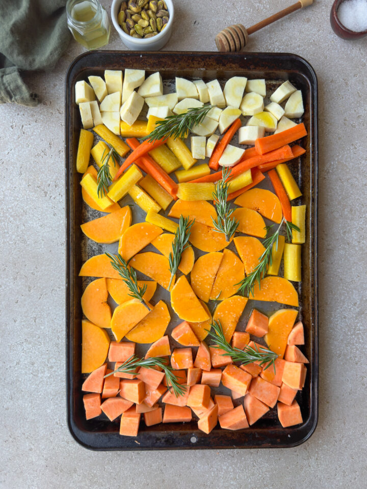 winter vegetables on a sheet pan with rosemary for roasting