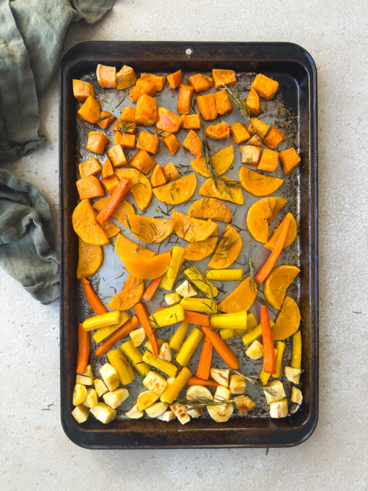 roasted vegetables with goat cheese and honey on a sheet pan
