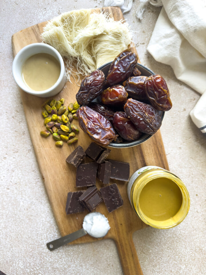 Ingredients to make Dubai chocolate bars including medjool dates, kataifi, pistachio butter, tahini and pistachios. 