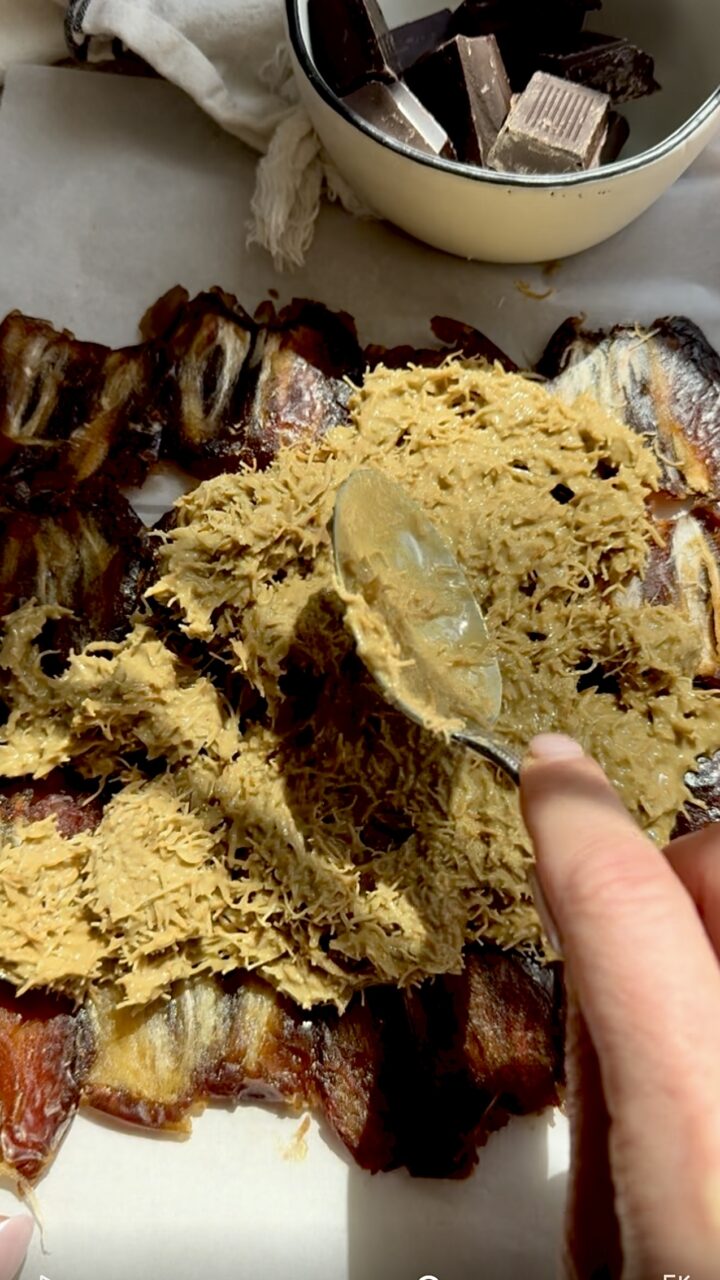 Spreading creamy pistachio and kataifi filling atop date layer of chocolate bars. 