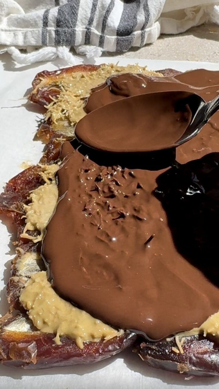 Evenly spreading the chocolate layer on Dubai chocolate bars. 