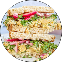 circular image with black frame of a chickpea salad sandwich
